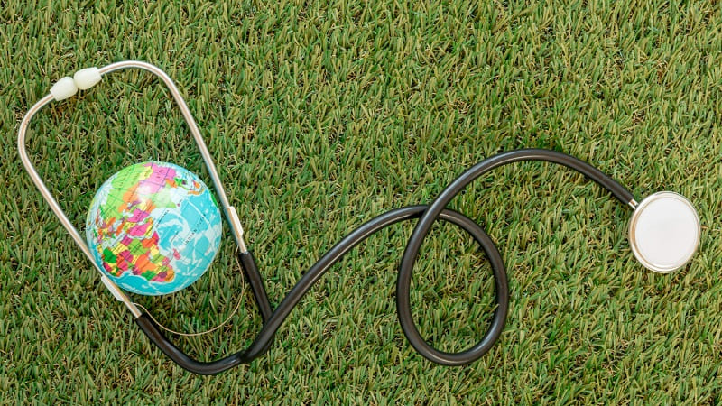 سماعة طبية على العشب مع كرة أرضية صغيرة