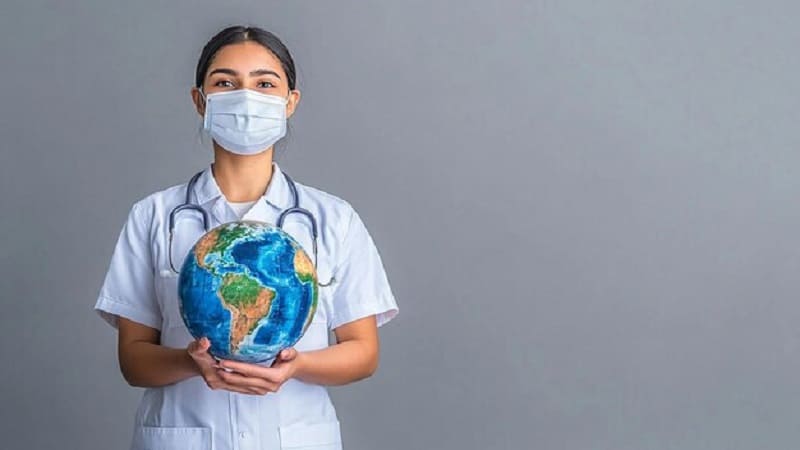 طبيبة تحمل الكرة الأرضية وترمز للسياحة العلاجية العالمية