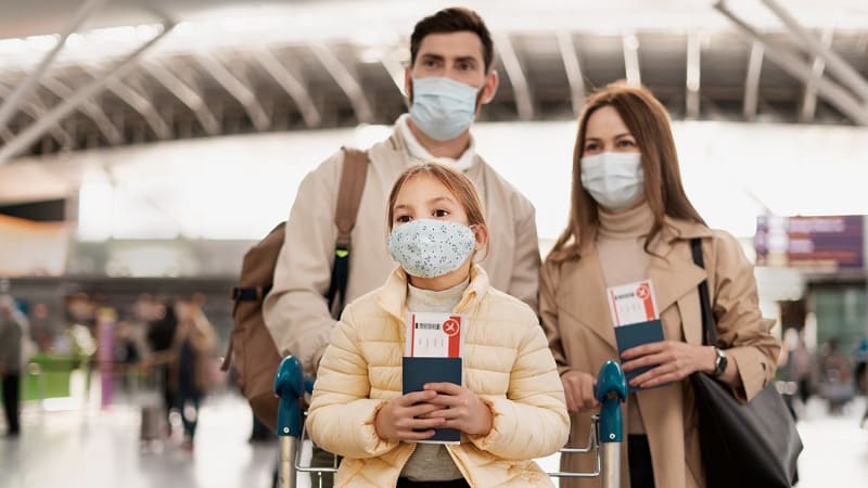 عائلة ترتدي الكمامات في المطار للسفر العلاجي