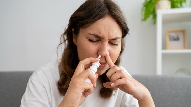 امرأة تستخدم بخاخ الأنف لعلاج التهاب اللحمية