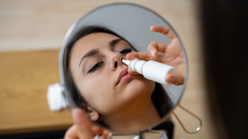 امرأة تضع جهاز استنشاق لعلاج مشاكل الأنف