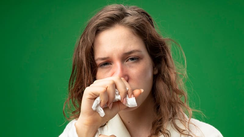 امرأة تعطس بسبب التهاب الأنف التحسسي