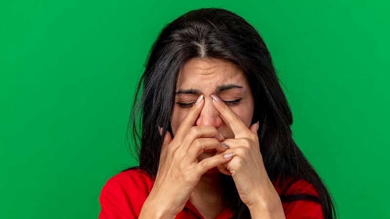 امرأة تمسك أنفها بسبب احتقان اللحمية