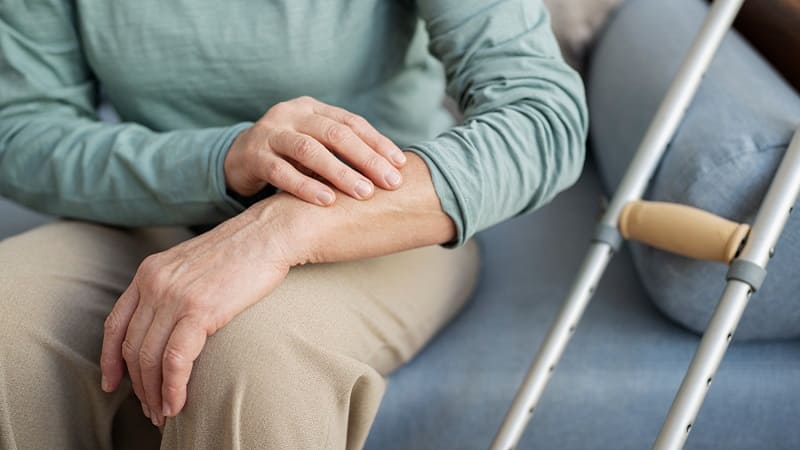 شخص يستخدم عكازًا بسبب آلام المفاصل الناتجة عن الروماتيزم