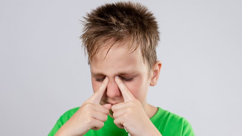 رجل يضغط على أنفه بسبب التهاب لحمية الانف وآلام الجيوب.